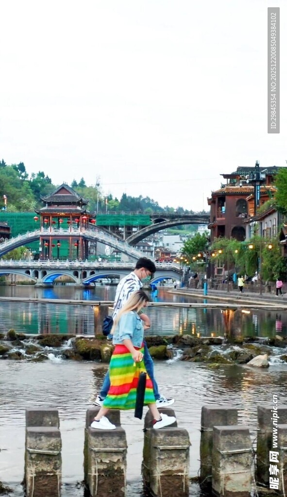 女子撑伞漫步水上石墩