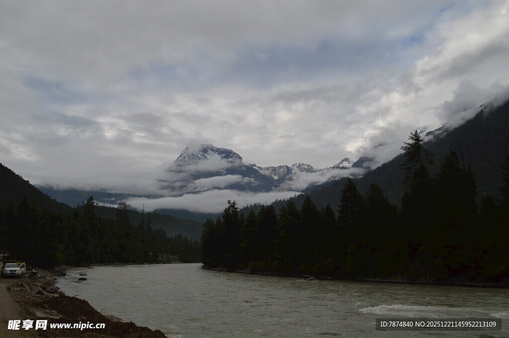 山间河流与远处云雾缭绕山峰