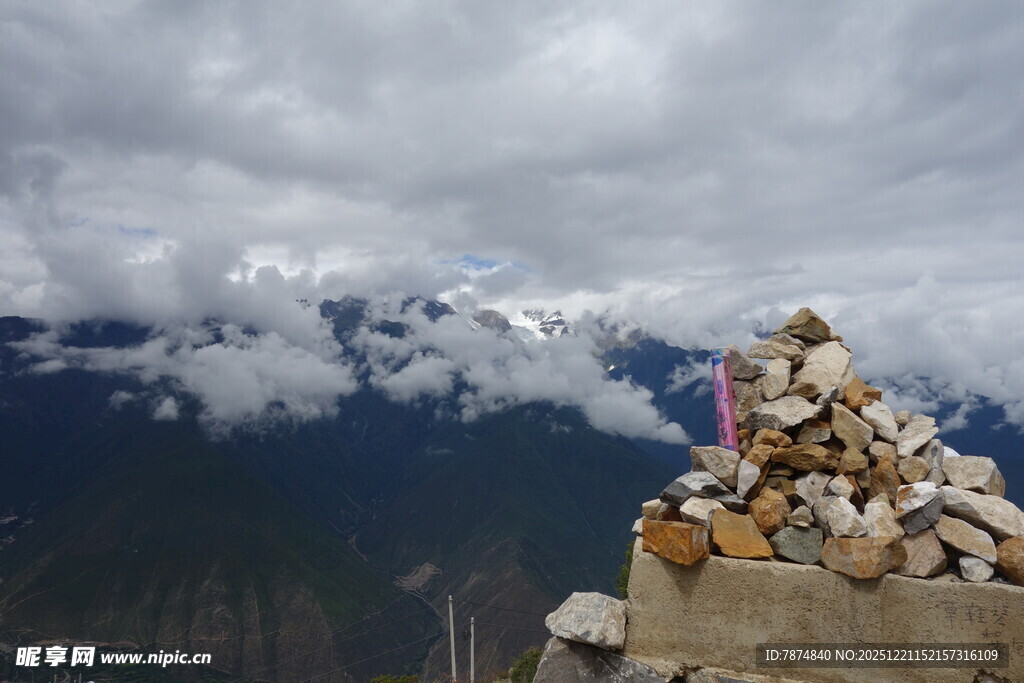 山间石堆与远处云雾雪山