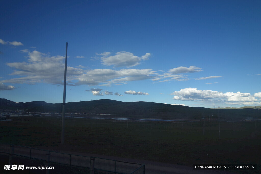 蓝天旷野间的电线杆