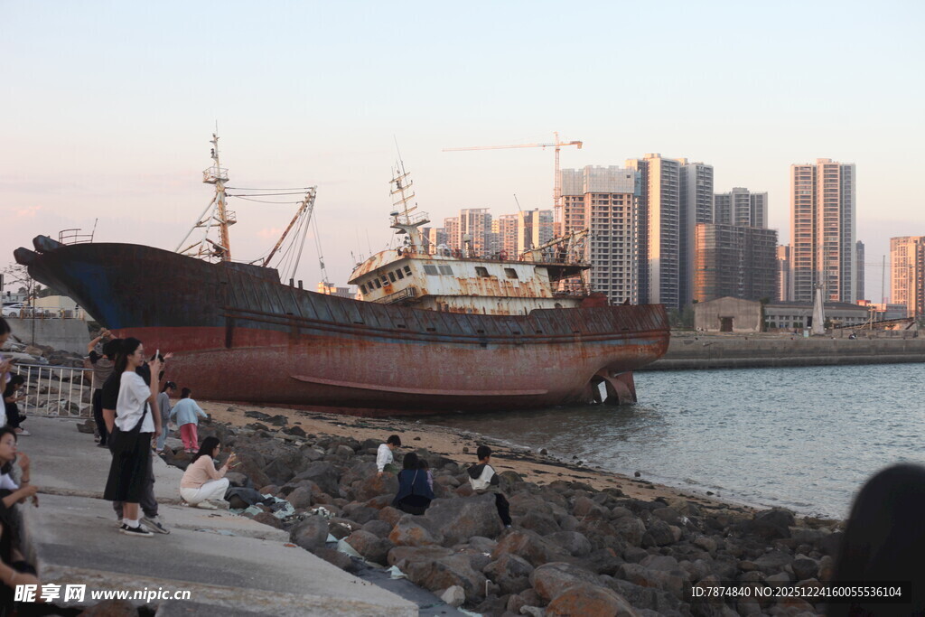 岸边旧船与远处高楼景象