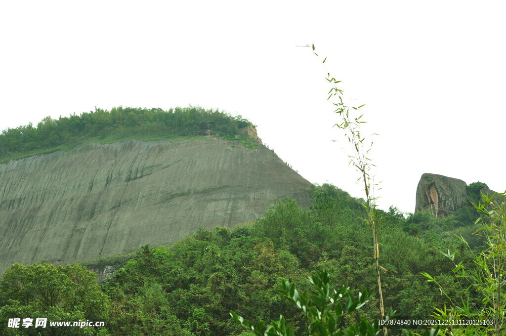 青山绿树环绕的陡峭崖壁