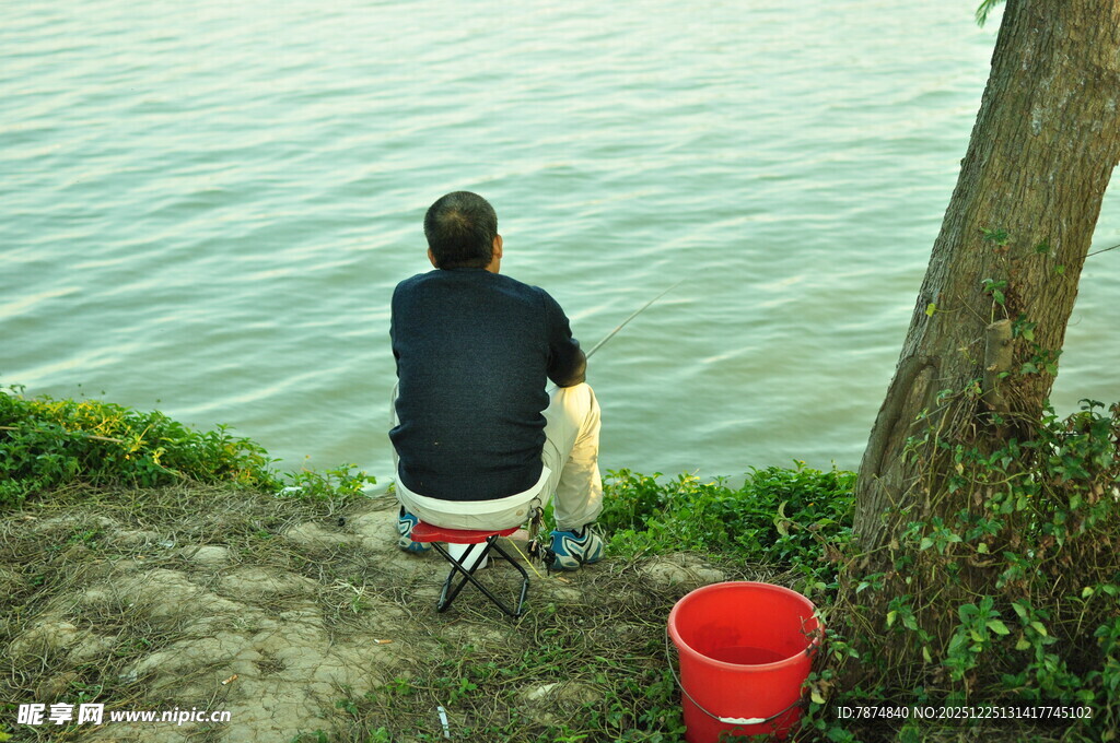男子岸边独坐临水垂钓