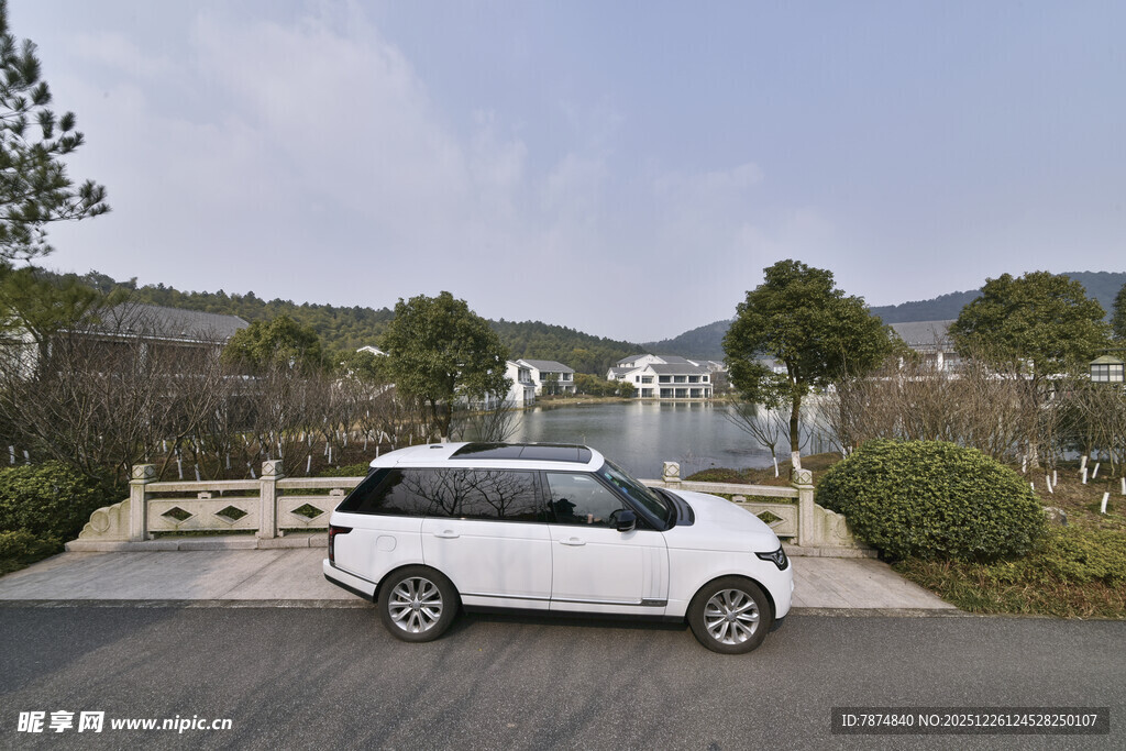 白色汽车停于山水风景间