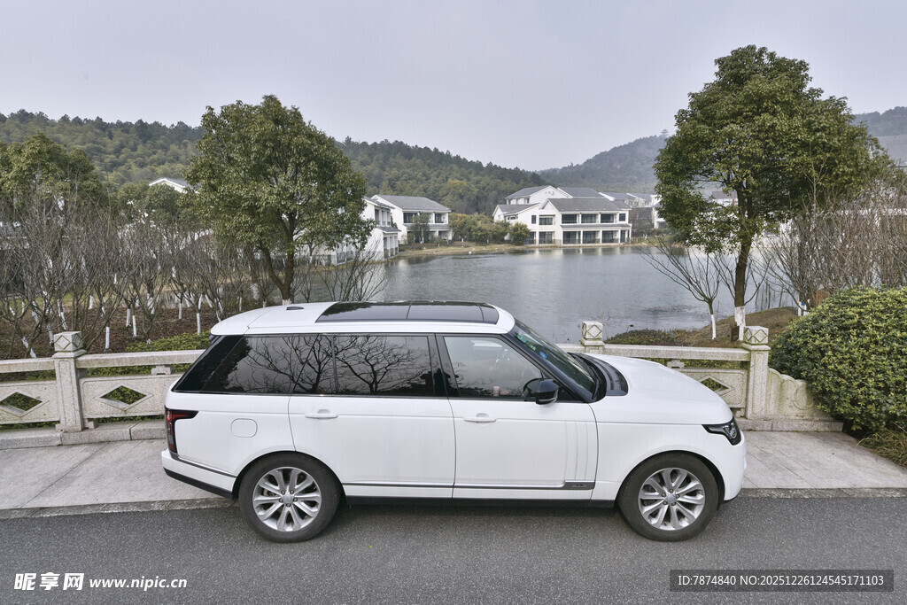 白色家用车停靠湖边美景处