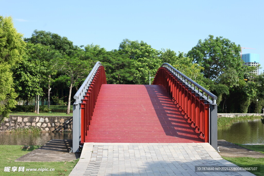 红色拱桥横跨绿意湖畔