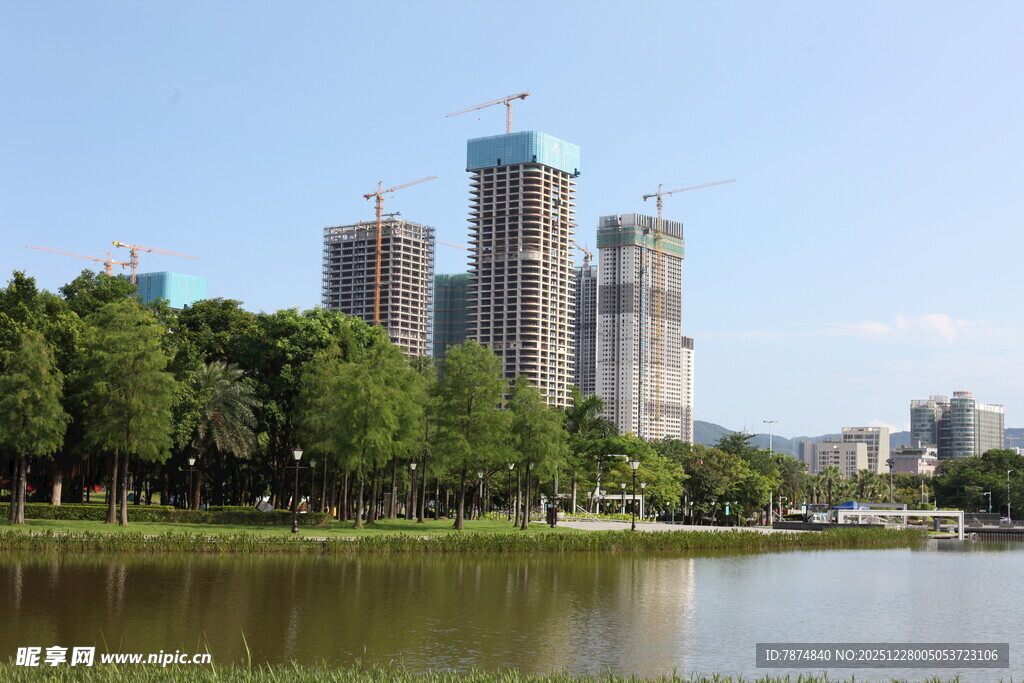 湖畔在建高楼与绿树景观
