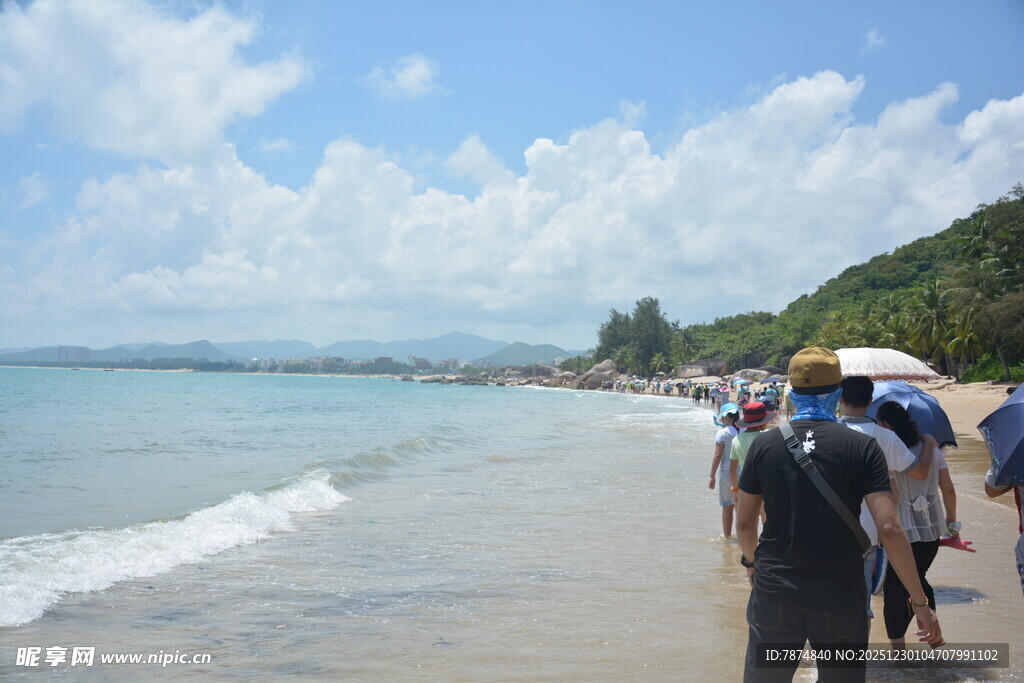 游客漫步美丽海滨沙滩