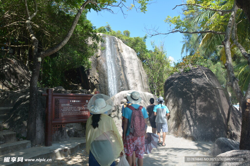 游客漫步于瀑布旁的小径