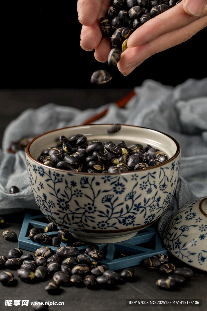 手撒黑豆于青花碗旁