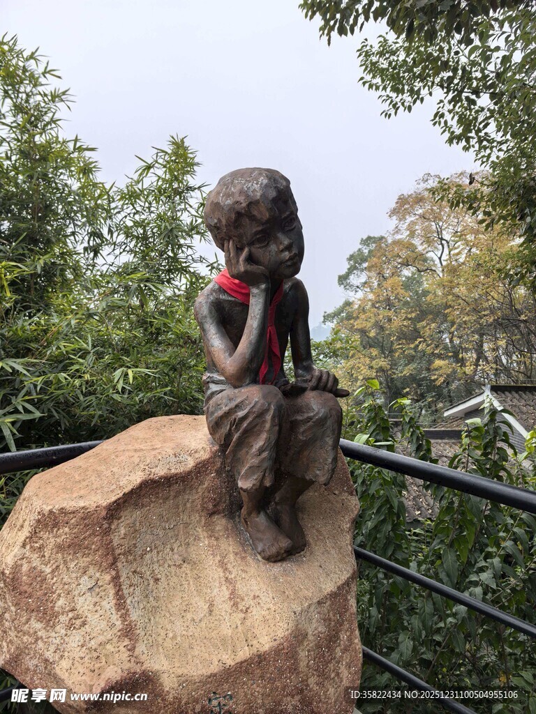 坐在石头上的孩童铜像