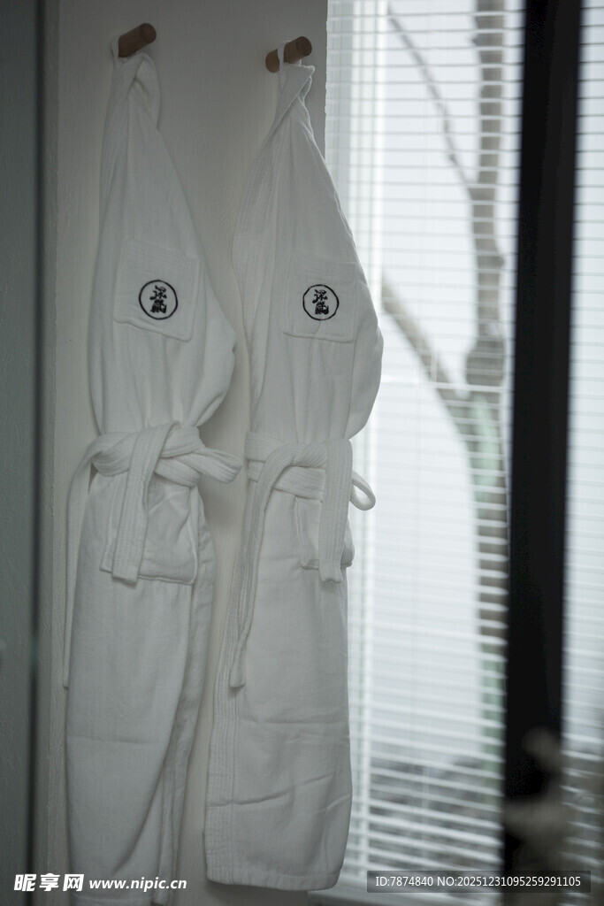 两件白色浴袍挂在窗边