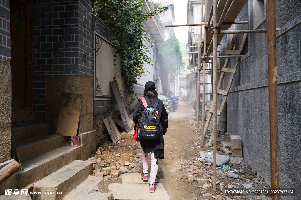 女孩穿行于狭窄破旧小巷