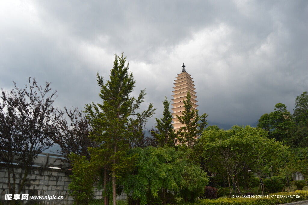 阴云下的古塔与葱郁树木