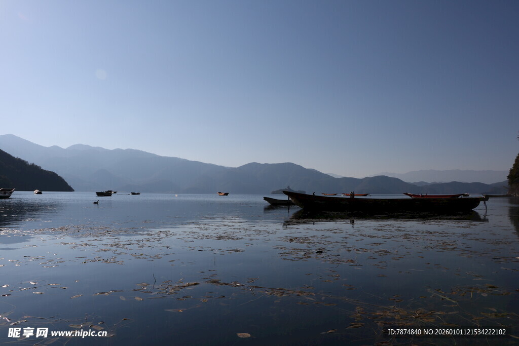 宁静湖面的孤舟与远山