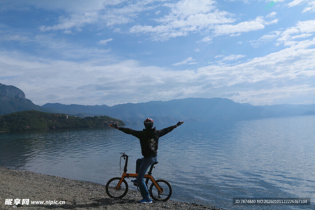 湖畔骑行者张开双臂赏景