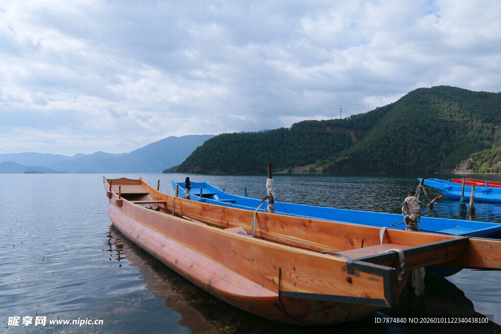 湖畔停泊的木船与蓝篷船