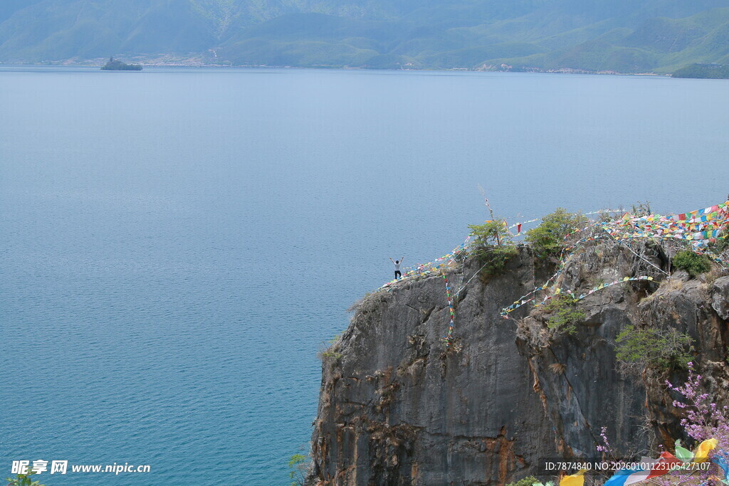 悬崖边的经幡与辽阔湖水