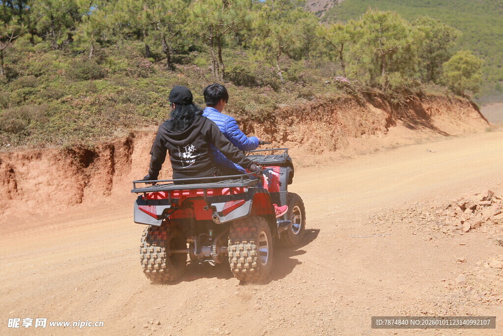 双人驰骋于沙地四轮摩托