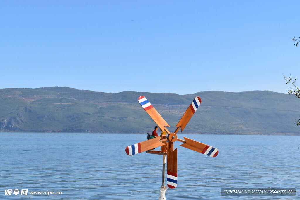 湖畔风车立于碧水蓝天间