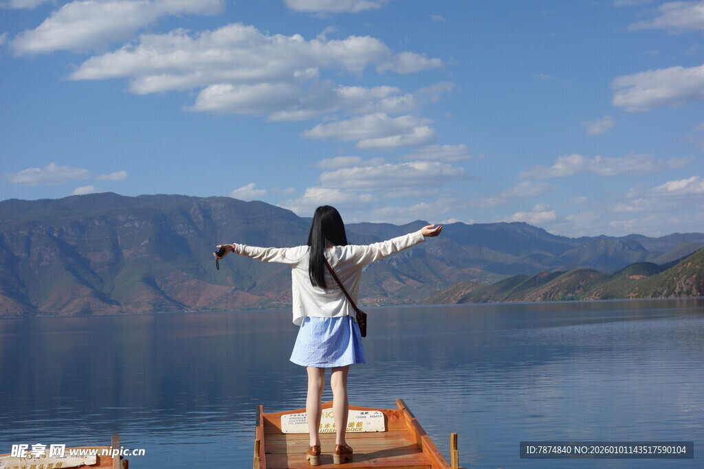 女孩于湖畔张开双臂赏景