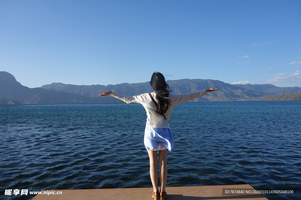 女子于湖畔栈桥舒展双臂
