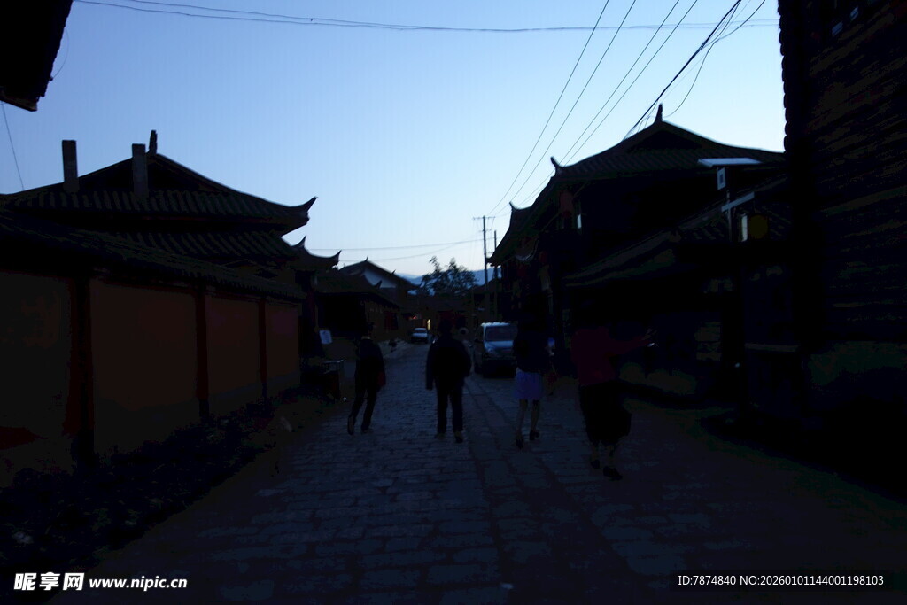 古巷暮色中的行人与建筑