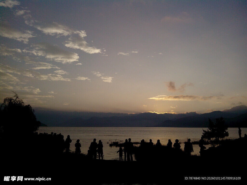 湖畔日落时的人群剪影