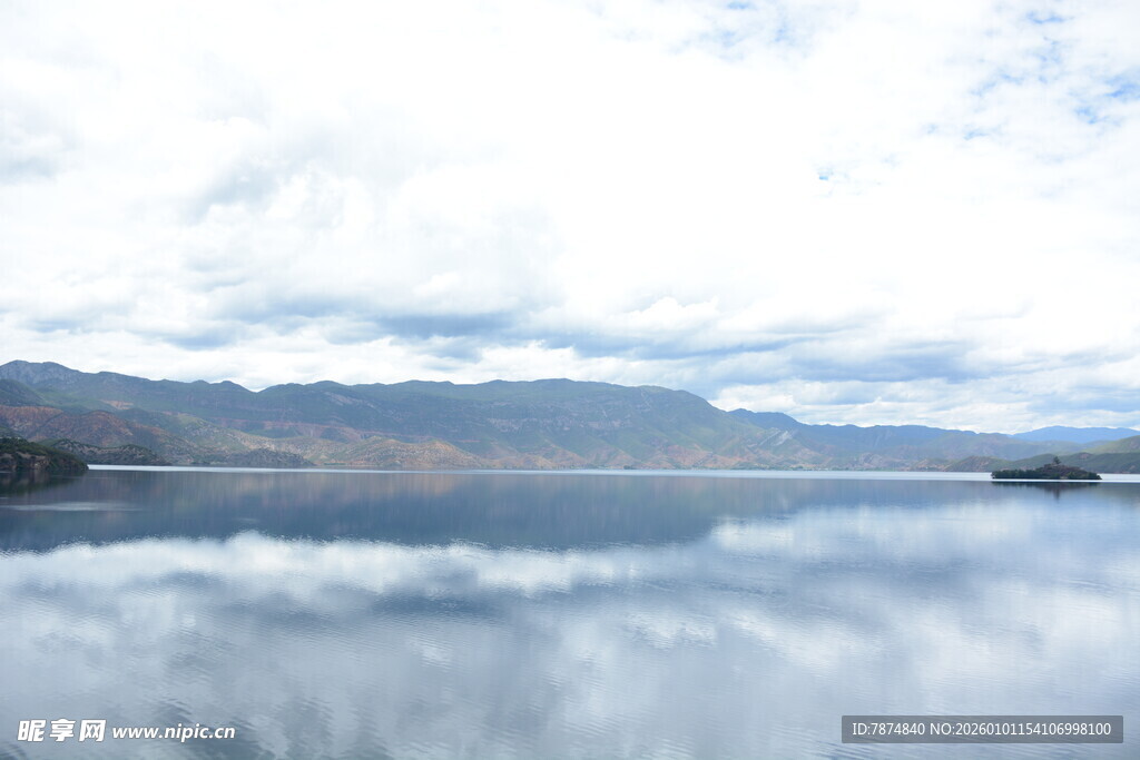 平静湖面倒映蓝天白云山峦