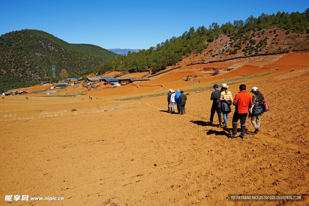 徒步者穿行于开阔黄土地