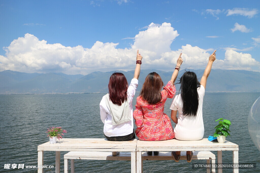 三女生坐露台眺望美丽湖景