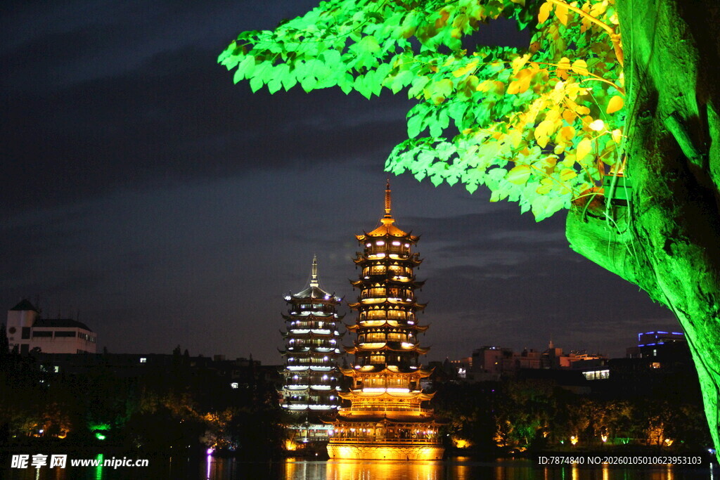 夜下古塔旁的璀璨发光树