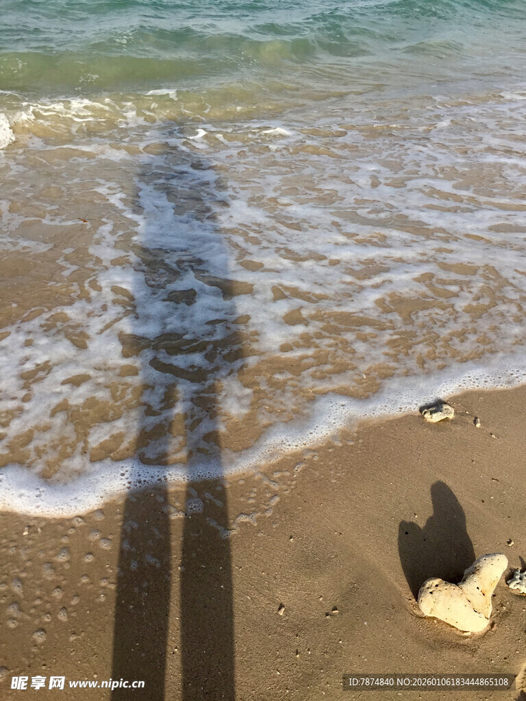 海边沙滩上的人影与贝壳