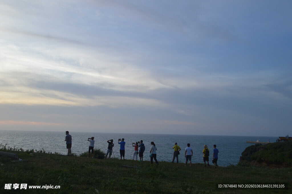 海边黄昏下的人群剪影