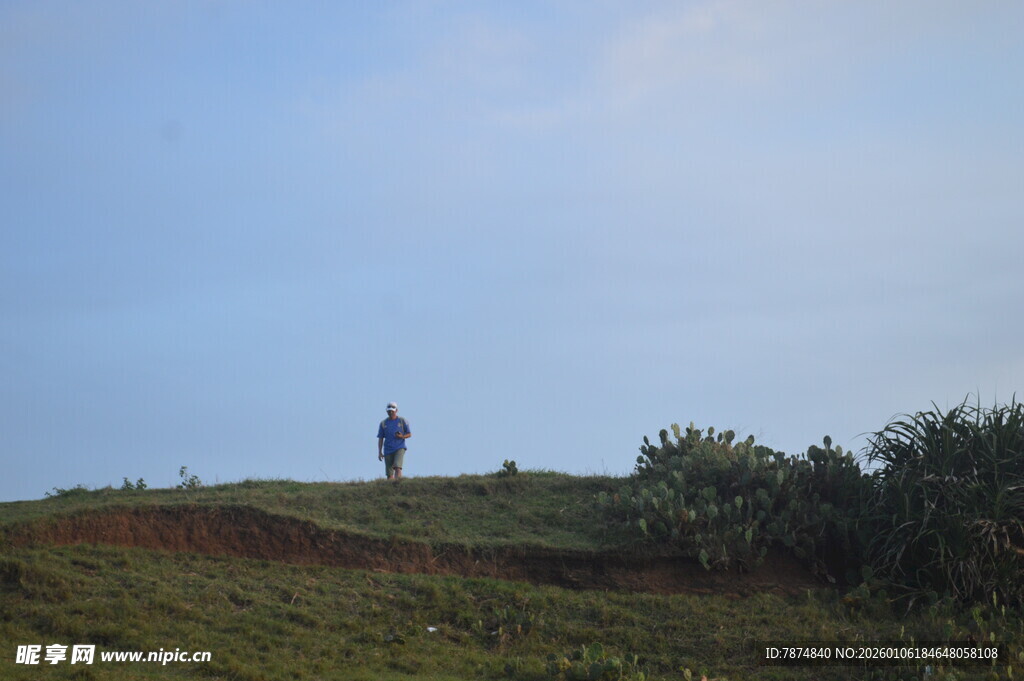 一人独站于绿意山丘之上