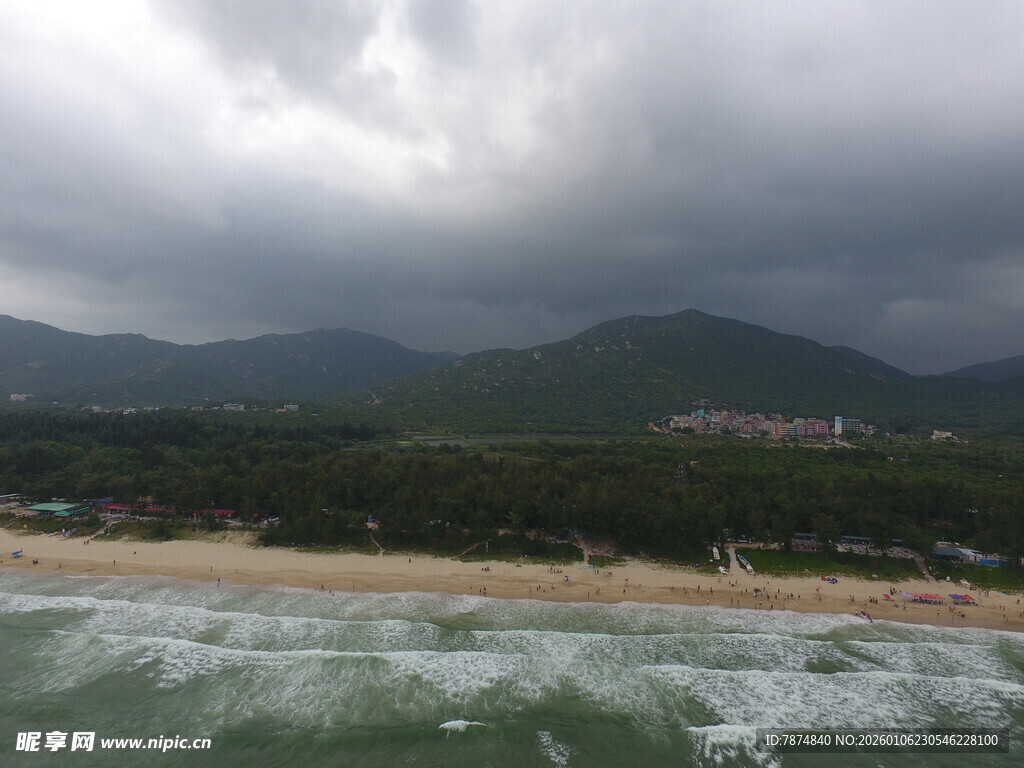 海边乌云下的山峦与沙滩