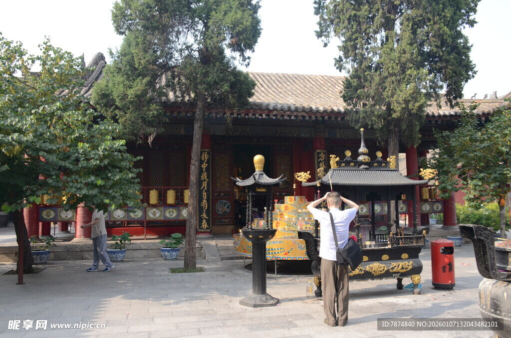 古寺前的游客与金色雕塑