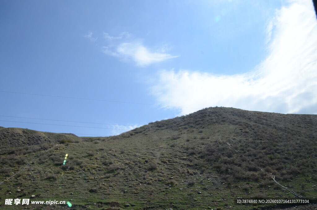 蓝天映衬下的翠绿山坡