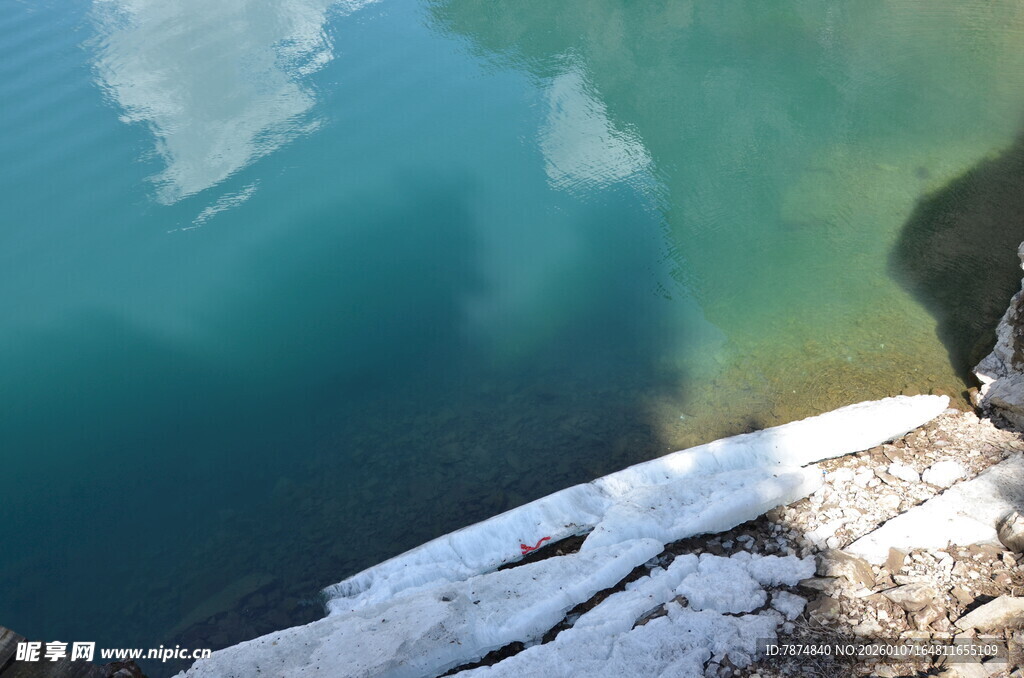 湖畔覆雪岩石与清透湖水