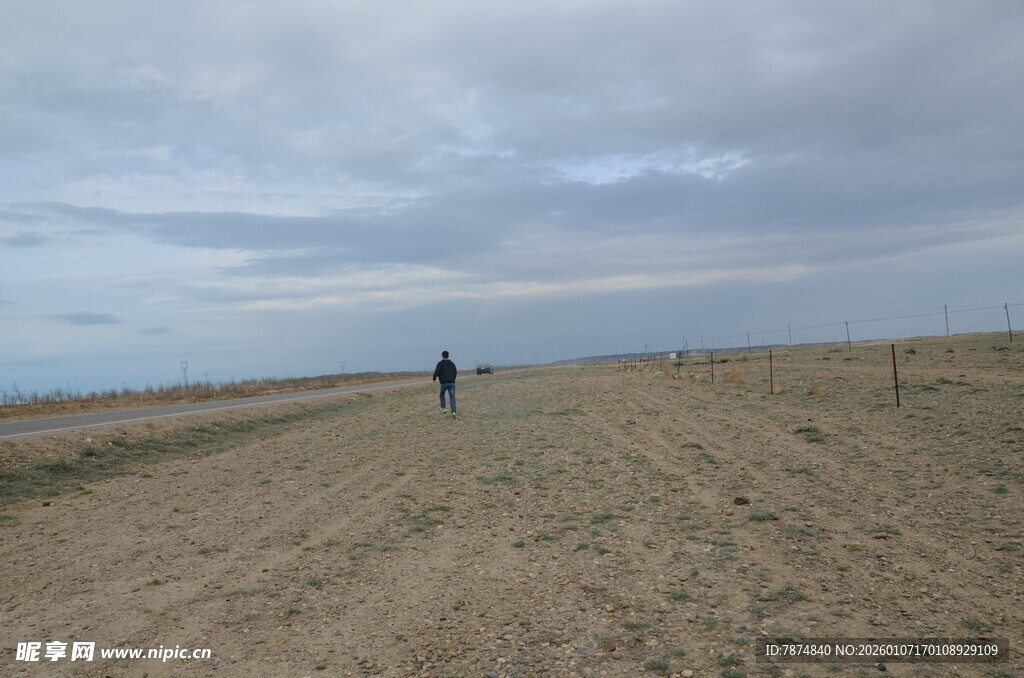 一人漫步空旷沙地海边