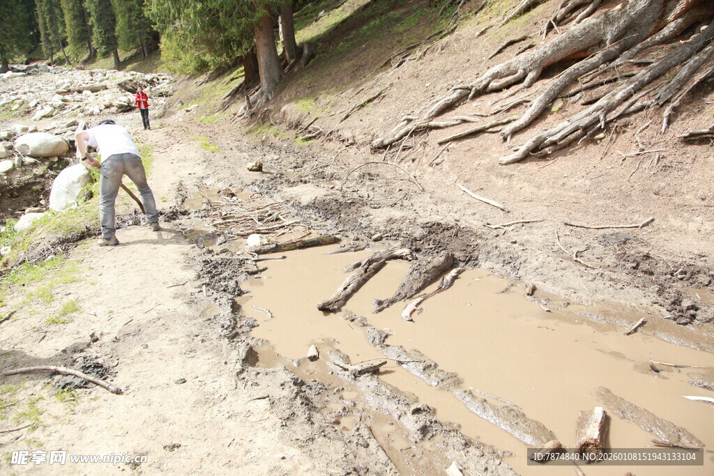 男子骑行于泥泞山间小道