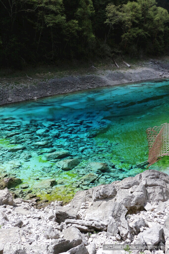 清澈蓝绿色湖水与岸边岩石