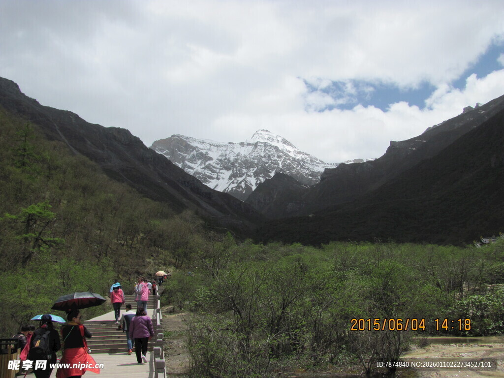 山间徒步者与远处雪山