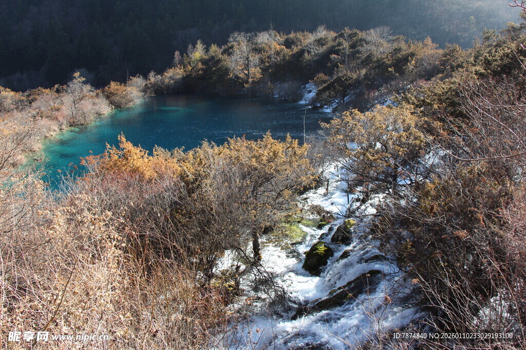 雪覆山林间的幽蓝湖泊