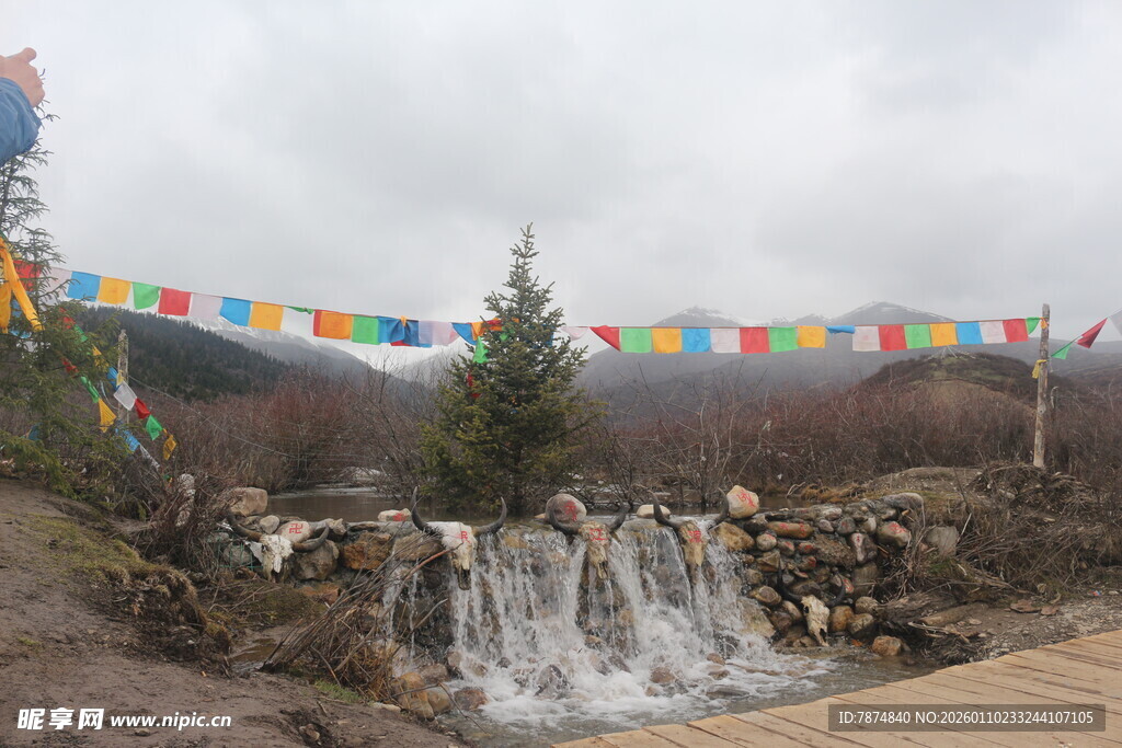 山间五彩经幡下的小瀑布