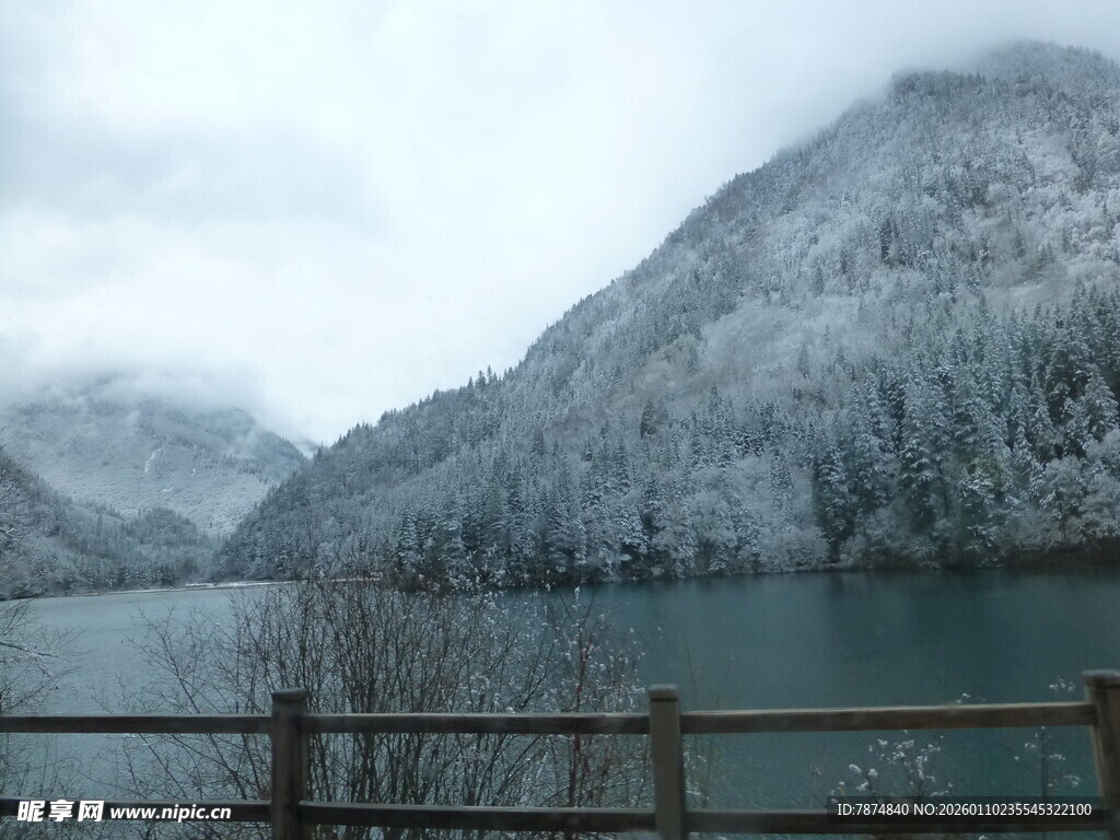 雪覆山峦下的静谧湖水