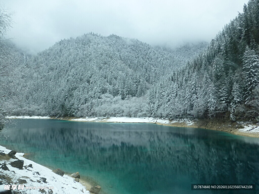 雪覆山林间的碧蓝湖水