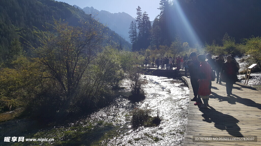 山间徒步者沿溪流前行