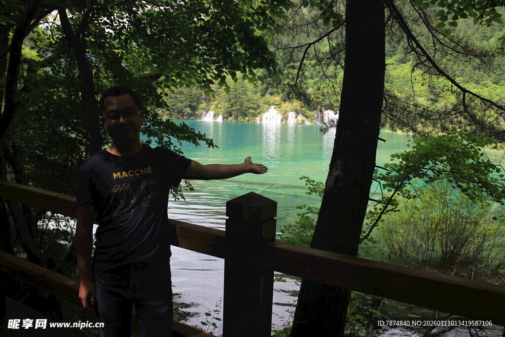 男子于林间赏碧绿湖水