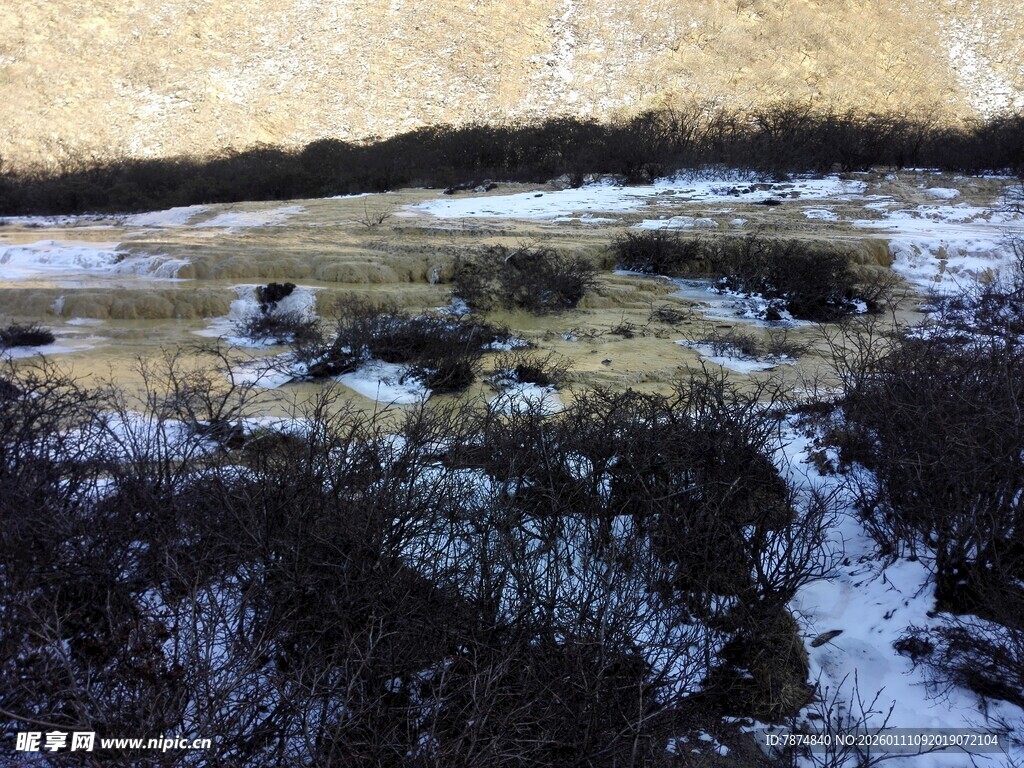 山间雪覆草地与溪流